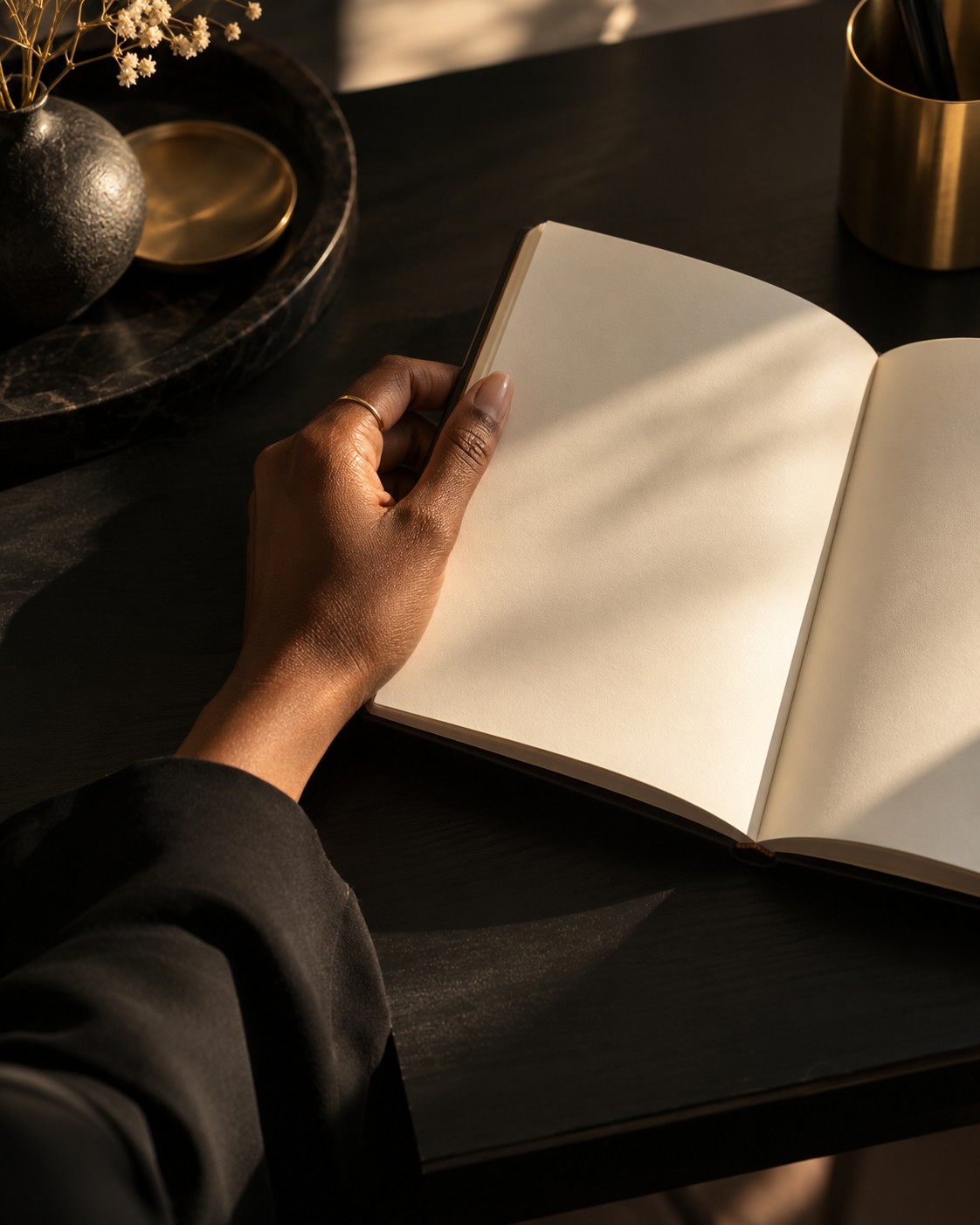 An open cream journal held in warm sunlight—a quiet space for reflection